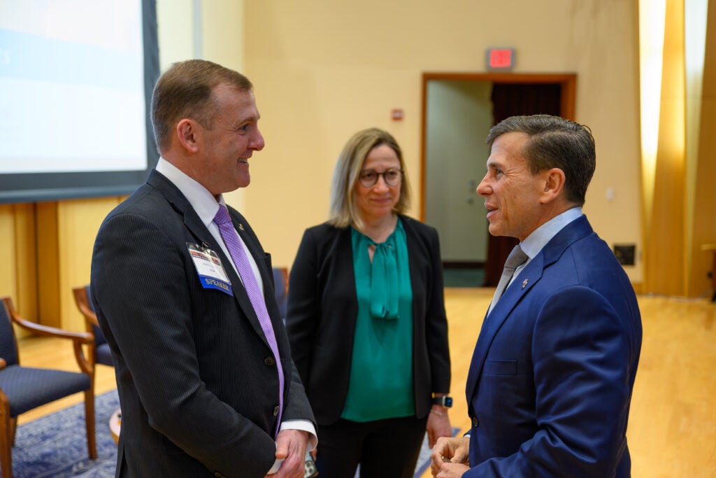 Three people in business attire in conversation